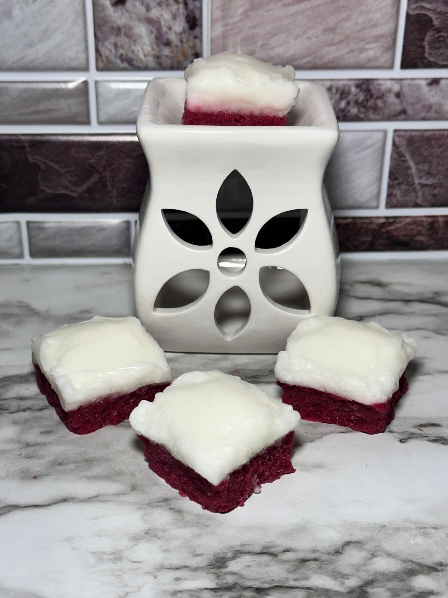 Rebanadas de pastel de terciopelo rojo con glaseado de queso crema y cera derretida